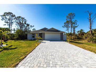 Charming single-story home featuring a gray exterior, well-manicured lawn, and a paved driveway leading to an attached two-car garage at 160 Green Pine Park, Rotonda West, FL 33947