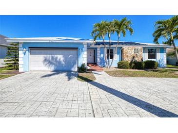 Charming blue single-story home with well-maintained landscaping, stone accents, and a spacious driveway and garage at 2180 Via Esplanade, Punta Gorda, FL 33950