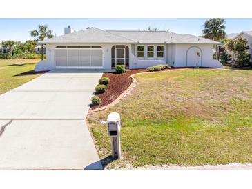 Well-maintained single-story home with a two-car garage, landscaped yard, and a concrete driveway at 3024 Caribbean Dr, Punta Gorda, FL 33950