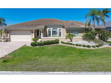 Charming single-story home featuring a well-manicured lawn and a welcoming two-car garage at 5032 La Costa Island Ct, Punta Gorda, FL 33950