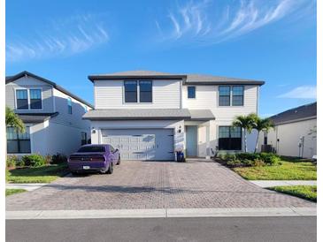 Beautiful two-story home with a brick driveway, two-car garage, and manicured landscaping at 2486 Buckthorn Loop, North Port, FL 34289