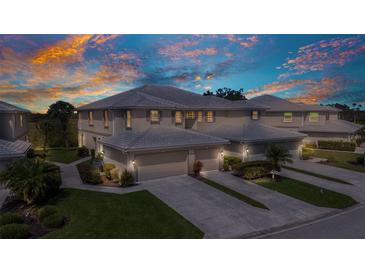 Beautifully landscaped townhome with tile roof, two-car garage and neutral exterior paint at 3393 Grand Vista Ct # 101, Port Charlotte, FL 33953