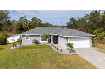 Charming single-story home with a well-manicured lawn, stone landscaping, and a paved driveway leading to the garage at 4373 Atwater Dr, North Port, FL 34288