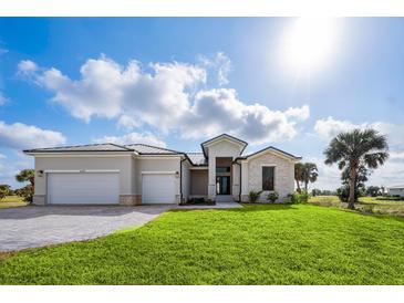 Beautiful new construction home featuring a three-car garage and manicured front lawn at 16440 Cape Horn Blvd, Punta Gorda, FL 33955