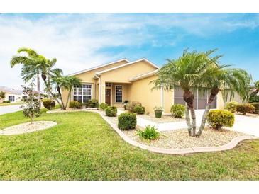 Charming single-story home featuring a well-manicured lawn, lush landscaping, and mature palm trees creating great curb appeal at 24321 Kintail Ct, Punta Gorda, FL 33980