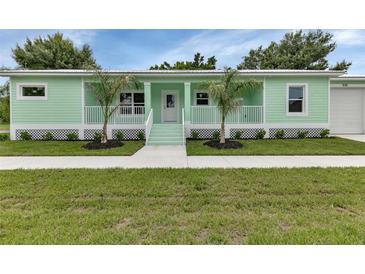 Charming mint green home with well-maintained lawn and beautiful landscaping at 535 Milus St, Punta Gorda, FL 33950