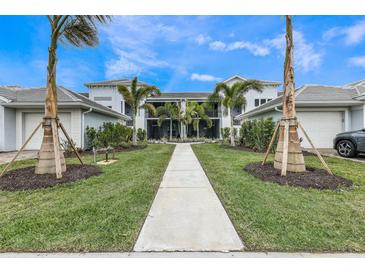 Beautiful condo with lush landscaping, manicured lawn, and walkway leading to the front entrance at 14234 Heritage Landing Blvd # 1016, Punta Gorda, FL 33955