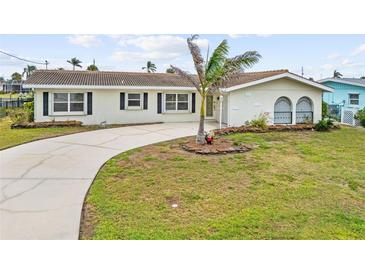 Charming home with a well-maintained front yard, a circular driveway, and mature landscaping at 1756 Boca Raton Ct, Punta Gorda, FL 33950