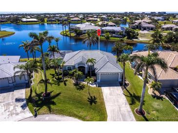 Stunning aerial view of a waterfront home with lush landscaping and a private pool at 17115 Barcrest Ln, Punta Gorda, FL 33955