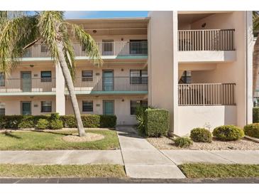 Attractive condo building featuring a lush, green landscaped yard and a well-maintained walkway leading to the entrance at 175 Kings Hwy # 717, Punta Gorda, FL 33983