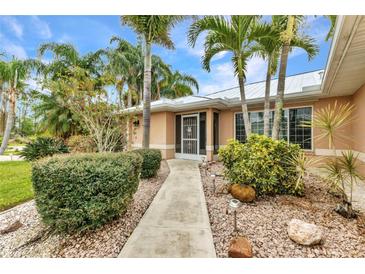 Inviting home exterior with lush landscaping and a charming walkway leading to the front entrance at 23531 Dunstan Ave, Port Charlotte, FL 33954