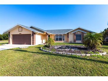 Charming single-story home featuring a well-manicured lawn and an attached two-car garage at 26201 Argentina Dr, Punta Gorda, FL 33983