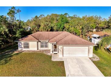 Well-maintained single-story home with a lush green lawn and an attached two-car garage at 4221 Circleville St, North Port, FL 34286