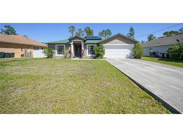 Charming single-story home featuring a well-maintained lawn, a two-car garage, and solar panels for energy efficiency at 1406 Woodcrest, North Port, FL 34286