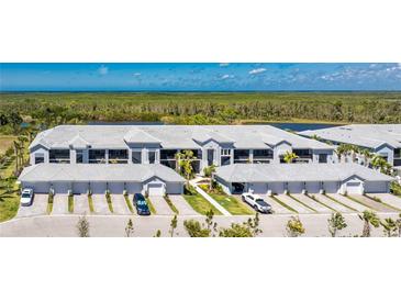 An aerial view of condo buildings showing a tranquil water view and attached garages with a paver driveway at 14281 Heritage Landing Blvd # 1411, Punta Gorda, FL 33955