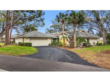 Charming home with a tile roof, an attached garage, and a curved driveway lined with well-maintained landscaping at 238 Southampton Dr # 319, Venice, FL 34293