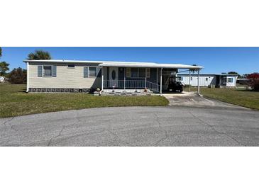 Charming mobile home with a carport and small front porch and decorative pink flamingos at 6821 Ocean Ct # Lot 30, North Port, FL 34287