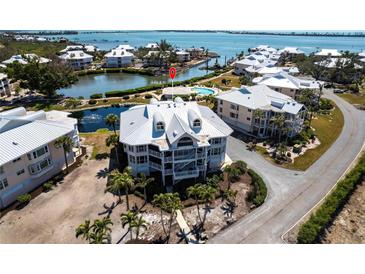 Stunning aerial view of a condo surrounded by water, lush landscaping, and community amenities at 11000 Placida Rd # 1501, Placida, FL 33946