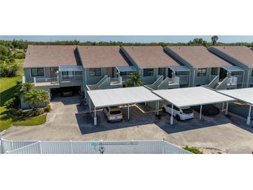 Close aerial of condo units featuring carports and balconies on each unit and well-kept exterior at 1408 San Cristobal Ave # 4, Punta Gorda, FL 33983