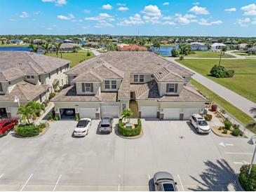 Stunning aerial view of townhomes boasting tile roofs, attached garages, and convenient parking, surrounded by lush landscaping at 17094 Acapulco Rd # 312, Punta Gorda, FL 33955