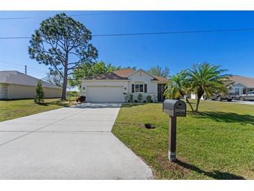 Charming single-story home with well-manicured lawn, mature trees, and a welcoming two car garage at 25199 Chiclayo Ave, Punta Gorda, FL 33983