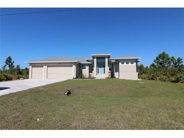 Charming single-story home featuring a three-car garage and a well-manicured lawn on a clear, sunny day at 9529 Calumet Blvd, Port Charlotte, FL 33981