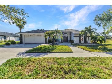 Charming home with a well-manicured lawn, lush landscaping, and a two-car garage at 1068 Harbour Cape Pl, Punta Gorda, FL 33983