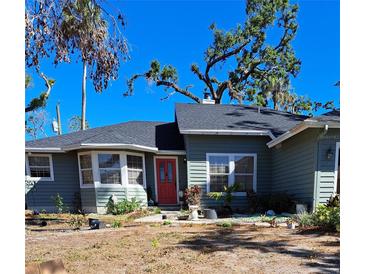 Charming single-story home featuring a red front door and a well-manicured lawn at 17056 Doyle Ave, Port Charlotte, FL 33954