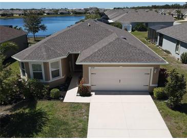 Inviting single-Gathering home with a two-car garage, manicured landscaping, and beautiful lakeside views at 25325 E Lenox Cir, Punta Gorda, FL 33950
