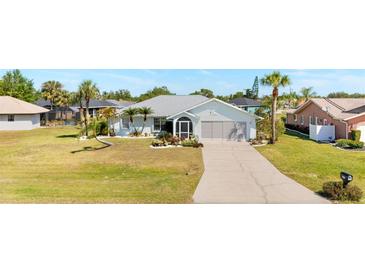 Charming single-story home with a well-manicured lawn, landscaped flowerbeds, and a two-car garage at 25730 Deep Creek Blvd, Punta Gorda, FL 33983