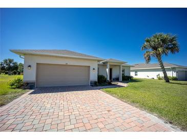 Charming single-story home featuring a brick driveway, two-car garage, and lush lawn at 359 Paramaribo St, Punta Gorda, FL 33983