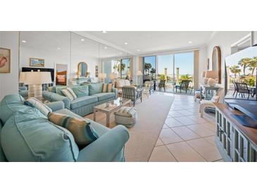 Bright living room with beach views, tile floors, and comfortable seating at 1212 Benjamin Franklin Dr # 102, Sarasota, FL 34236