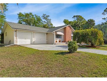 Charming home featuring a two-car garage, well-manicured lawn, and mature trees providing ample shade at 17380 Shirley Ave, Port Charlotte, FL 33948
