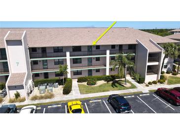 Three-story condo building showcasing parking and tropical landscaping at 175 Kings Hwy # 736, Punta Gorda, FL 33983