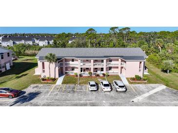 Exterior view of a pink two-story condo building with multiple parking spaces in front at 179 Boundary Blvd # 4, Rotonda West, FL 33947