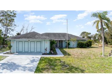 Charming single-story home featuring a spacious three-car garage and well-manicured lawn at 535 Ramblewood St, Port Charlotte, FL 33953