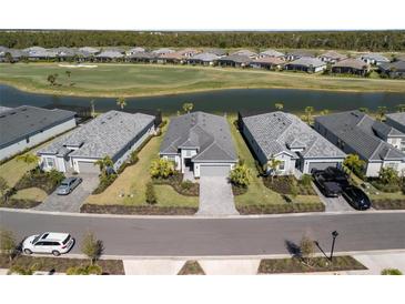 Aerial view of elegant homes bordering a scenic pond and golf course within a vibrant community at 15931 Sugar Hill Dr, Punta Gorda, FL 33982
