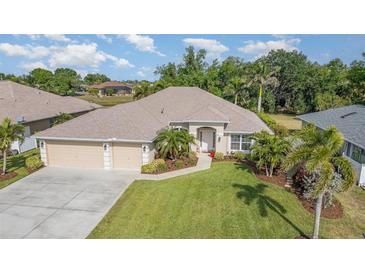 Beautiful single-story home featuring a manicured lawn, lush landscaping, and a three-car garage, creating curb appeal at 2132 Nuremberg Blvd, Punta Gorda, FL 33983
