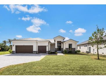 Beautiful home featuring a three car garage, modern design and well-maintained landscaping at 24259 Peppercorn Rd, Punta Gorda, FL 33955
