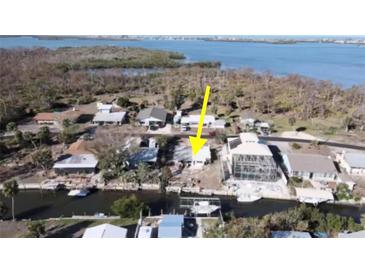 This aerial view showcases the waterfront home with canal access and lush surrounding vegetation at 2061 S Pine St, Englewood, FL 34224