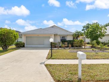 Charming single-story home with a well-maintained lawn and two-car garage at 478 Winwood Ct, Port Charlotte, FL 33954