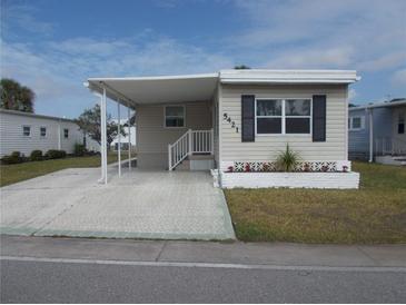 Charming home featuring a covered carport, decorative accents, and a well-maintained lawn at 5421 Holiday Park Blvd, North Port, FL 34287