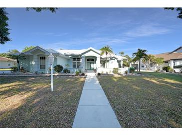 Charming single-story home with a well-manicured lawn, mature trees, and a welcoming walkway at 1065 Harbour Glen Pl, Punta Gorda, FL 33983