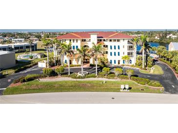 Beautiful low angle daytime exterior view of the condo with palm trees and well maintained landscaping at 1340 Rock Dove Ct # 132, Punta Gorda, FL 33950