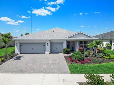 Charming single-story home with a three-car garage and meticulously maintained landscaping with palm trees at 16064 Shoreline Dr, Punta Gorda, FL 33982