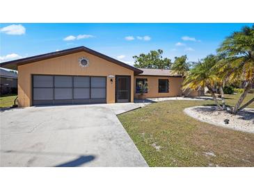 Charming single-story home with a well-manicured lawn, mature palm trees, and a two-car garage at 2333 Rio De Janeiro Ave, Punta Gorda, FL 33983