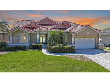 Charming single-story home with well-manicured lawn, tropical landscaping, and a striking red tile roof at 341 Segovia Dr, Punta Gorda, FL 33950