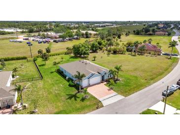 Sprawling single-story home with a 2-car garage, a brick driveway, and a lush, green lawn at 7028 N Plum Tree, Punta Gorda, FL 33955