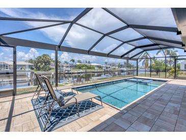 Relaxing covered outdoor pool with lounge chairs overlooking the canal and beautiful homes at 280 Belvedere Ct, Punta Gorda, FL 33950