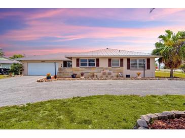 Charming home with a lush lawn, decorative flower boxes, and a circular driveway with ample parking at 4168 Harbor Blvd, Port Charlotte, FL 33952